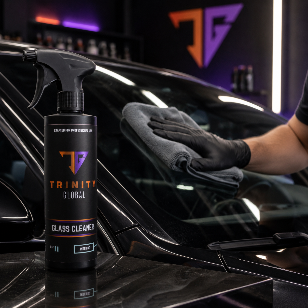 Trinity Global glass cleaner bottle with a gloved hand cleaning a car window.